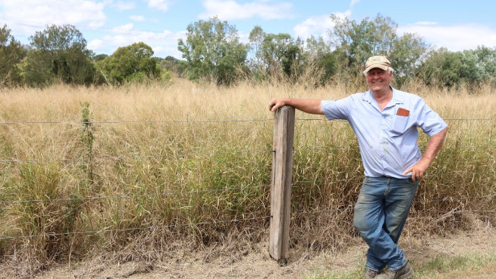 Man standing in front of hay stack